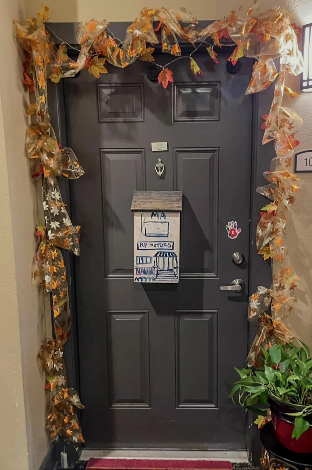 A resident's hallway doorway decorated with seasonal wreaths, photos, and keepsakes