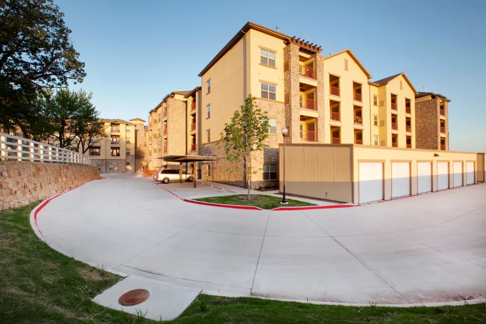A tree-lined drive winding through the community, past the resident garages